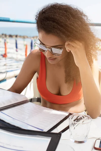 Piękna Młoda Kobieta Czytanie Menu Rano Siedząc Restauracji Plaży Lato — Zdjęcie stockowe