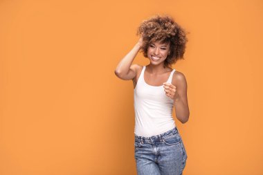 Gülümseyerek, sarı arka plan üzerinde poz güzel mutlu Afrikalı-Amerikalı kadın. Olumlu duygular.