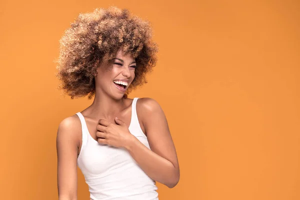 Beautiful happy african american woman smiling, posing on yellow background. Positive emotions.