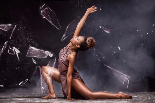 Genç güzel Afrikalı-Amerikalı kadın su ve cam üzerindeki poz.