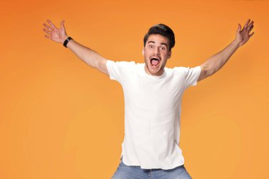 Sarı stüdyo arka plan üzerinde izole fotoğraf genç gülümseyen bir adam atlama. Mutlu yakışıklı adam.