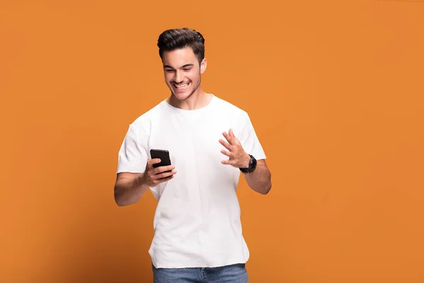 Sorprendido Joven Hombre Guapo Feliz Con Teléfono Móvil Mano Posando —  Fotos de Stock