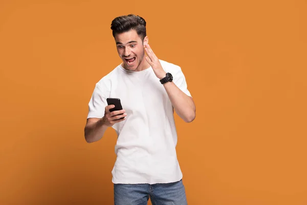 Sorprendido Joven Hombre Guapo Feliz Con Teléfono Móvil Mano Posando —  Fotos de Stock