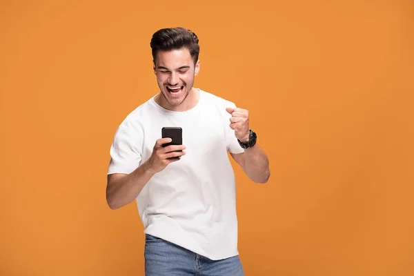Przystojny Uśmiechający Się Podekscytowany Mężczyzna Trzymając Telefon Komórkowy Pozowanie Żółty — Zdjęcie stockowe