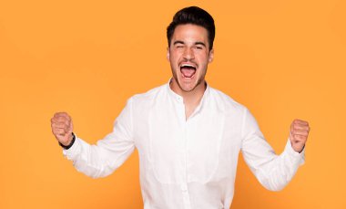 Sarı stüdyo arka plan üzerinde zarif şık giysiler içinde yakışıklı genç gülümseyen fotoğraf.