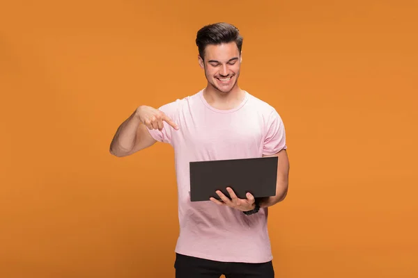 Feliz Joven Guapo Sosteniendo Ordenador Portátil Posando Sobre Fondo Estudio — Foto de Stock