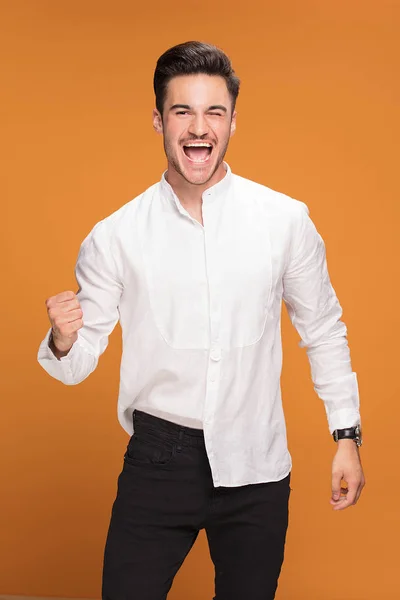 イエロー スタジオの背景にエレガントな流行の服でハンサムな若い男の笑顔写真 — ストック写真