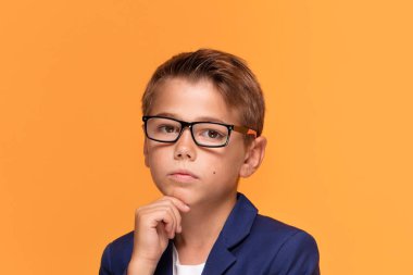 Şık takım elbise zarif küçük adam. Stüdyo vurdu. Genç çocuk moda gözlük takıyor poz