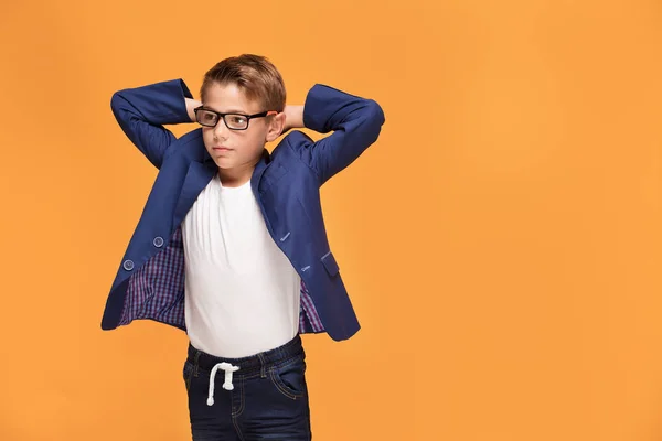 Piccolo Ragazzo Elegante Posa Sul Backgroud Studio Arancione Indossando Occhiali — Foto Stock