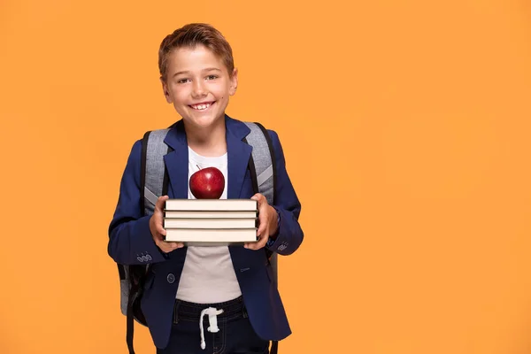 Kleiner Schuljunge Mit Rucksack Vor Orangefarbenem Hintergrund Mit Büchern Und — Stockfoto