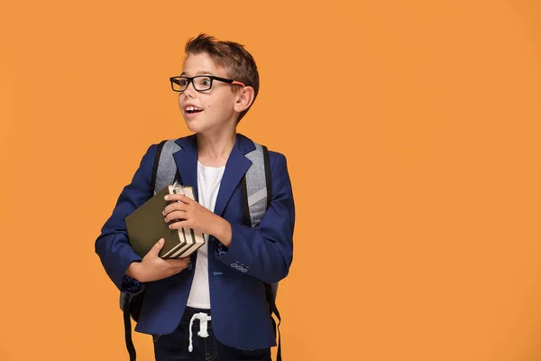 Kleiner Schuljunge Mit Brille Und Rucksack Vor Orangefarbenem Hintergrund Bücher — Stockfoto