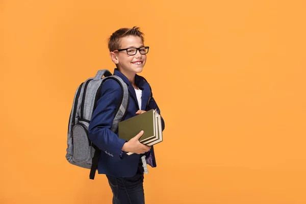 Niño Escuela Gafas Con Mochila Pie Sobre Fondo Naranja Sosteniendo — Foto de Stock