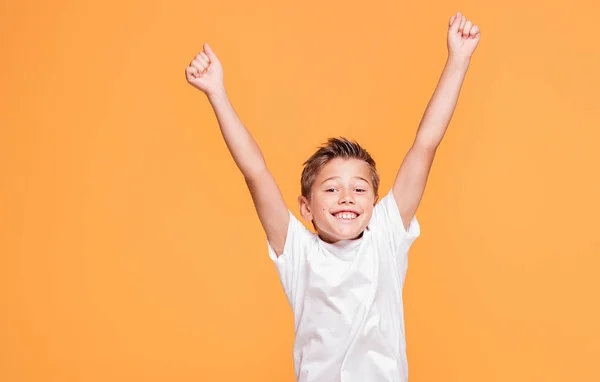 小さな学校の男の子黄色の背景でスタジオでジャンプします 幸せな子供時代の概念 — ストック写真