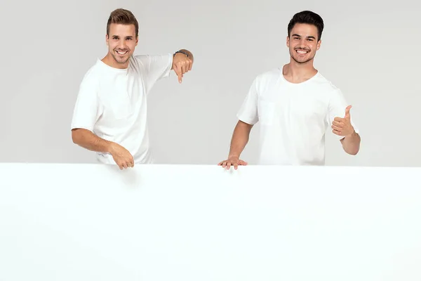 Two Young Handsome Guys Holding Blank White Banner Signboard Isolated — Stock Photo, Image