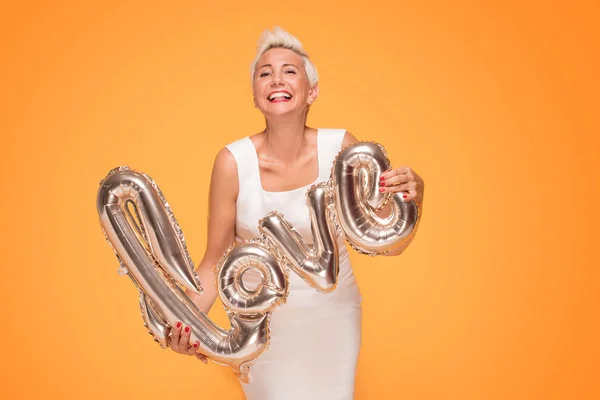 Atractiva Mujer Mediana Edad Sosteniendo Globo Amor Dorado Sonriendo Cámara — Foto de Stock