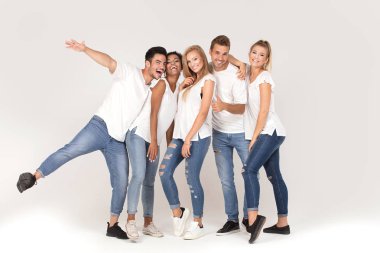 Gençlerin grup gülümseyen ve having fun birlikte, stüdyoda poz beyaz gömlek giymiş çok etnik gruptan oluşan çekici.