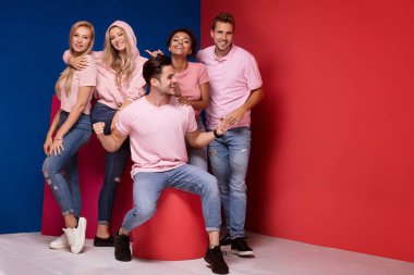 Gençlerin grup gülümseyen ve birlikte eğlenmek, renkli arka plan üzerinde poz çok etnik gruptan oluşan çekici.