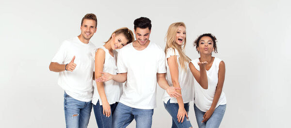 Group of young multi-ethnic attractive people wearing white shirts, smiling and having fun together, posing in studio. 