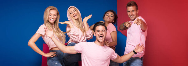 Group of young multi-ethnic attractive people smiling and having fun together, posing on colorful background.