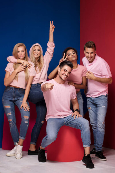 Group of young multi-ethnic attractive people smiling and having fun together, posing on colorful background.