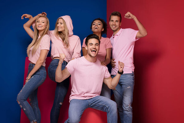 Group of young multi-ethnic attractive people smiling and having fun together, posing on colorful background.