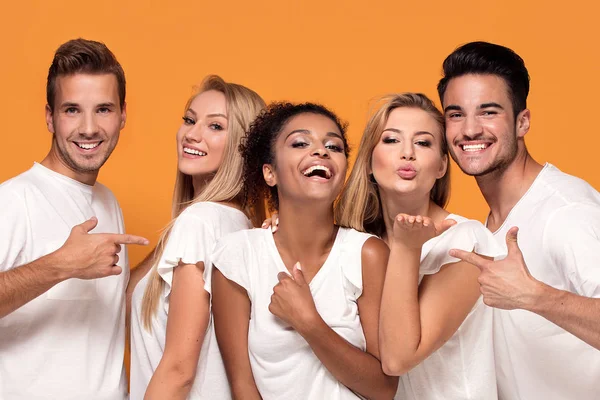 Cinco Jóvenes Multiétnicos Sonriendo Cámara Posando Sobre Fondo Estudio Naranja — Foto de Stock