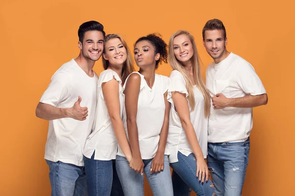 Cinco Jóvenes Multiétnicos Sonriendo Cámara Posando Sobre Fondo Estudio Naranja — Foto de Stock