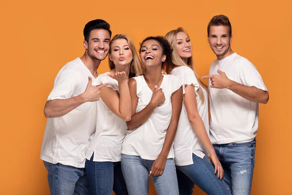若い多民族の人々 カメラに笑顔白カジュアル シャツにオレンジ スタジオ背景にポーズ — ストック写真