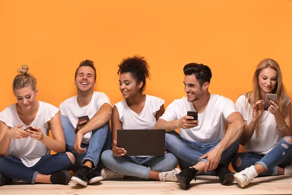 Grupo Jóvenes Multirraciales Mirando Teléfonos Móviles Sentados Suelo Pasando Tiempo — Foto de Stock