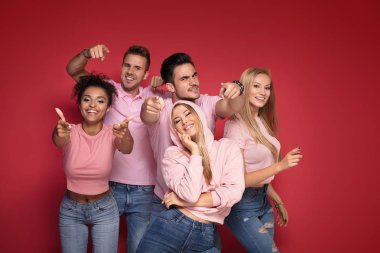 Gençlerin grup gülümseyen ve birlikte eğlenmek, renkli arka plan üzerinde poz çok etnik gruptan oluşan çekici.