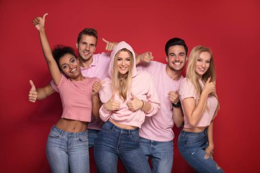 Gençlerin grup gülümseyen ve birlikte eğlenmek, renkli arka plan üzerinde poz çok etnik gruptan oluşan çekici.