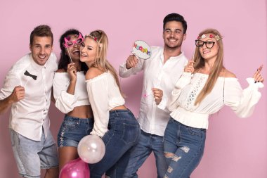 Gençlerin grup birlikte parti, pembe studio arka plan üzerinde poz güzel.
