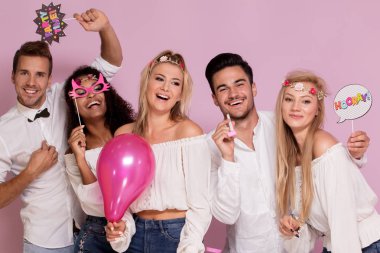 Gençlerin grup birlikte parti, pembe studio arka plan üzerinde poz güzel.