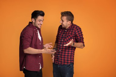 Mutlu genç moda iki adam akıllı telefon stüdyoda kullanarak.