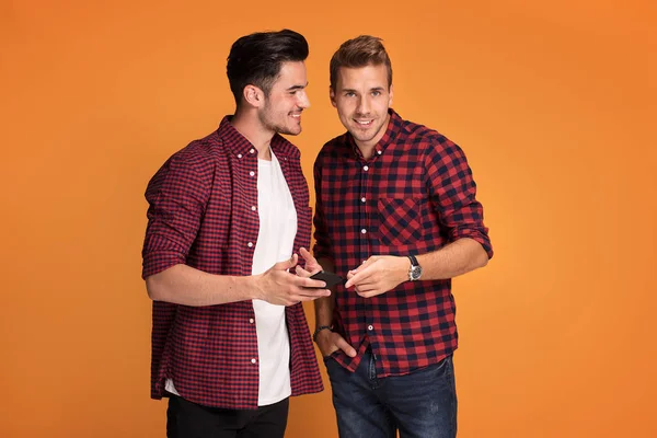 Happy Young Fashionable Two Men Using Smart Phone Studio — Stock Photo, Image