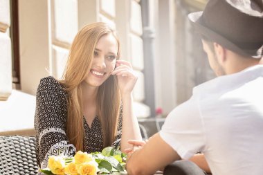 Güzel genç Açık havada kalma gül buketi ile çift. Yakışıklı adamla mutlu sarışın çekici kız.