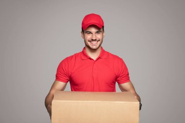 Teslimat kavramı - gülümseyen Kafkas kurye adam bir kutu paket holding.