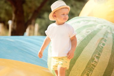 Güneşli bir günde parkta oynarken küçük çocuk. Şık bir şapka bebek. Mutlu çocukluk.
