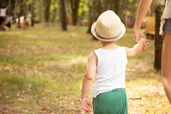 晴れた日に公園でお母さんと歩いている小さな男の子 ファッショナブルな帽子の赤ん坊 幸せな子供時代 — ストック写真