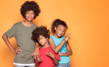 Mutlu birlikte poz, gülüyor, eğleniyor renkli giysiler içinde üç afro çocuk gülümseyen.