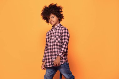 Moda gömlek Afro-Amerikan küçük adam. Stüdyo vurdu. Genç çocuk sarı arka plan üzerinde poz.