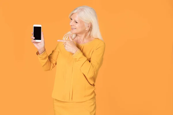 Seniorin posiert mit Handy. — Stockfoto