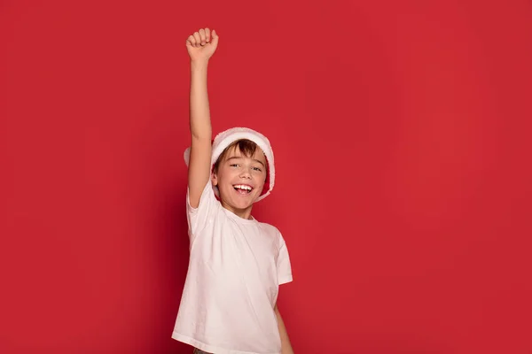 Usmíval Šťastný Mladík Pózuje Santa Claus Klobouk Červené Studio Pozadí — Stock fotografie