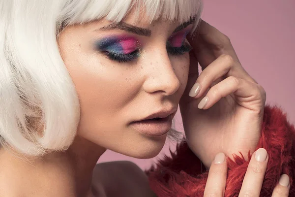 Beauty portrait of attractive woman in colorful glamour makeup and white wig.