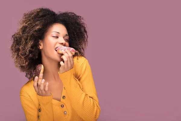 Genç Afro Amerikalı Kadın Donut Yemek Pembe Arka Plan Üzerinde — Stok fotoğraf