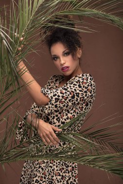 Afro-Amerikan güzel kadın moda hayvan baskı elbiseyle poz.