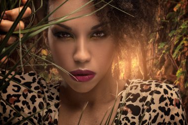 Yeşil ormanın içinde poz Afro-Amerikan güzel kadın. Gülümsemek güzellik portresi.