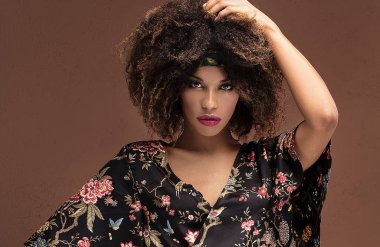 Studio moda fotoğraf güzel Afrikalı-Amerikalı kadının kahverengi arka plan üzerinde. Şık bir görünüm .