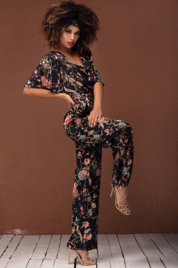 Studio moda fotoğraf güzel Afrikalı-Amerikalı kadının kahverengi arka plan üzerinde. Şık bir görünüm .