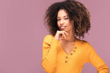 Gülümseyerek mutlu bir Afrikalı-Amerikalı kadın. Güzel kadın varoluş portre. Genç duygusal afro kadın. İnsan duyguları, yüz ifadesi kavramı. Pembe bir arka plan.